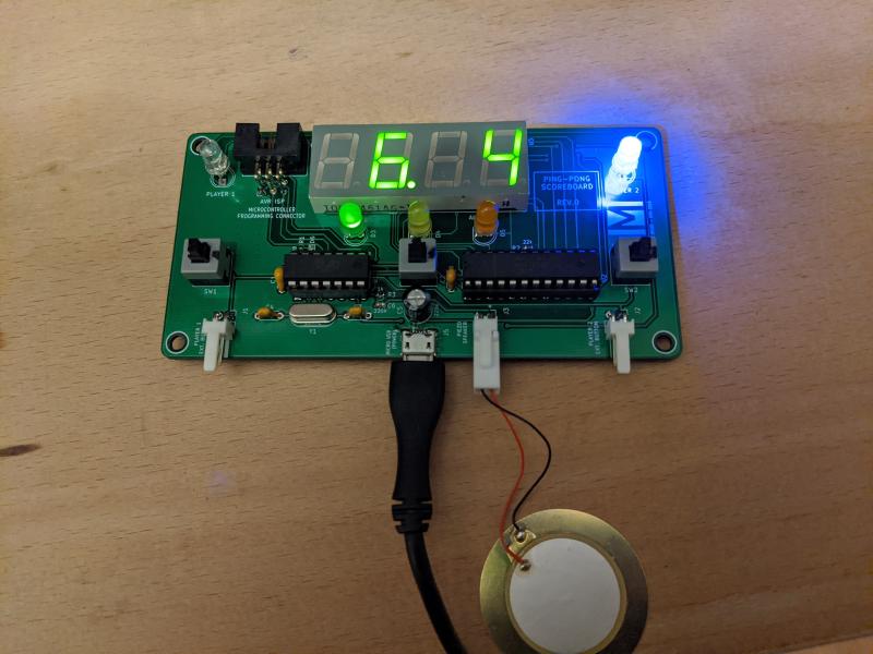 PCB version of the scoreboard, powered up, with the display and some LEDs on